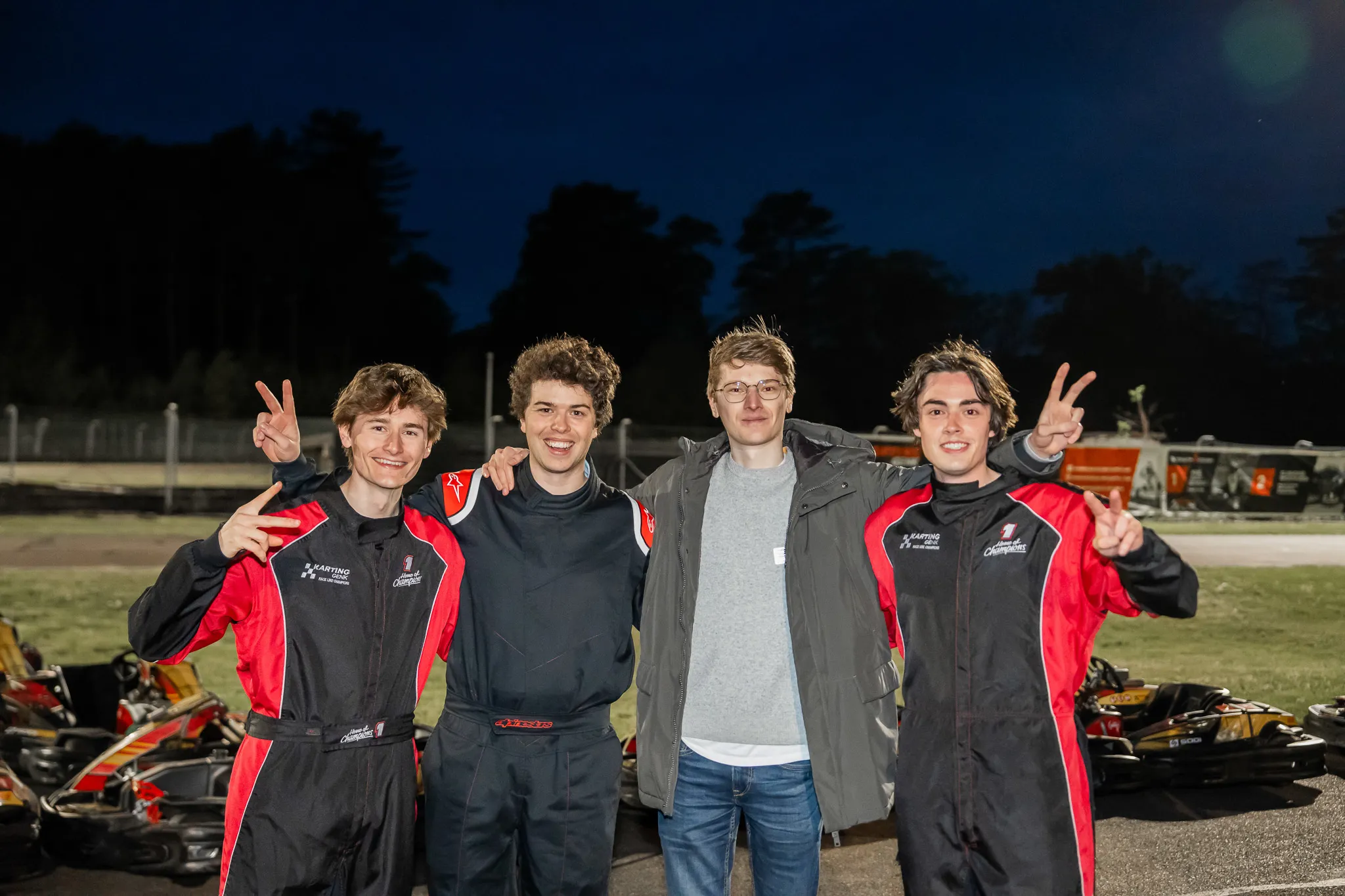 Team The Nines poseert na afloop van de race in de schemering op Karting Genk.